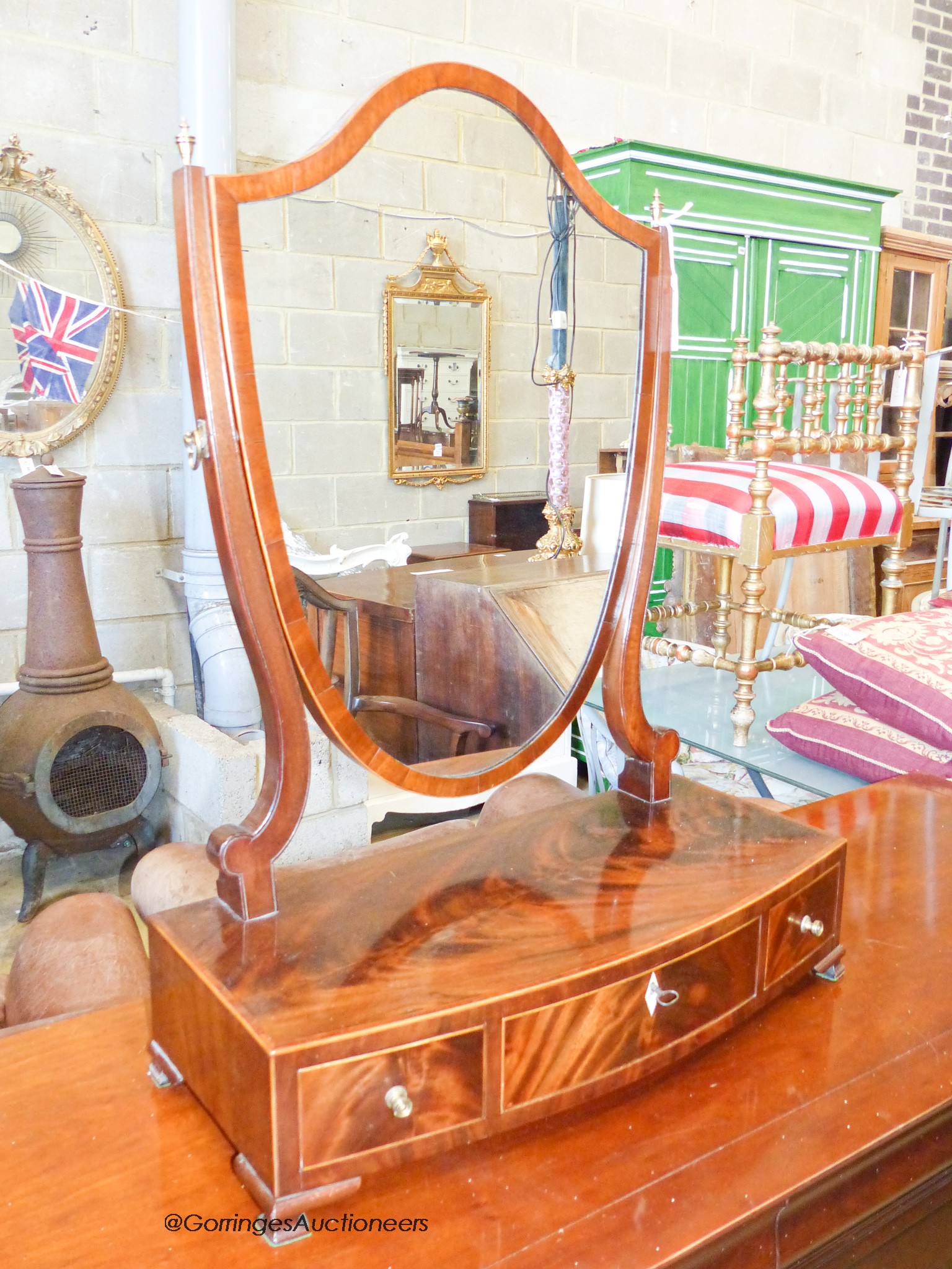 A George III banded mahogany bow front box base three drawer toilet mirror, width 59cm, depth 30cm, height 82cm
